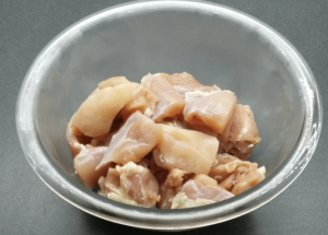 Raw chicken cubes in a bowl