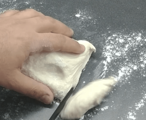 Cutting the dough with a knife.