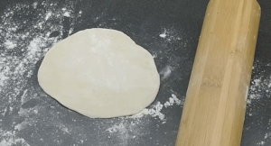 Pita bread dough rolled and flattened to a circle