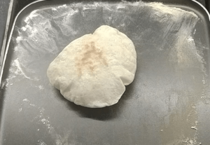Pita bread puffed in a skillet on the stovetop