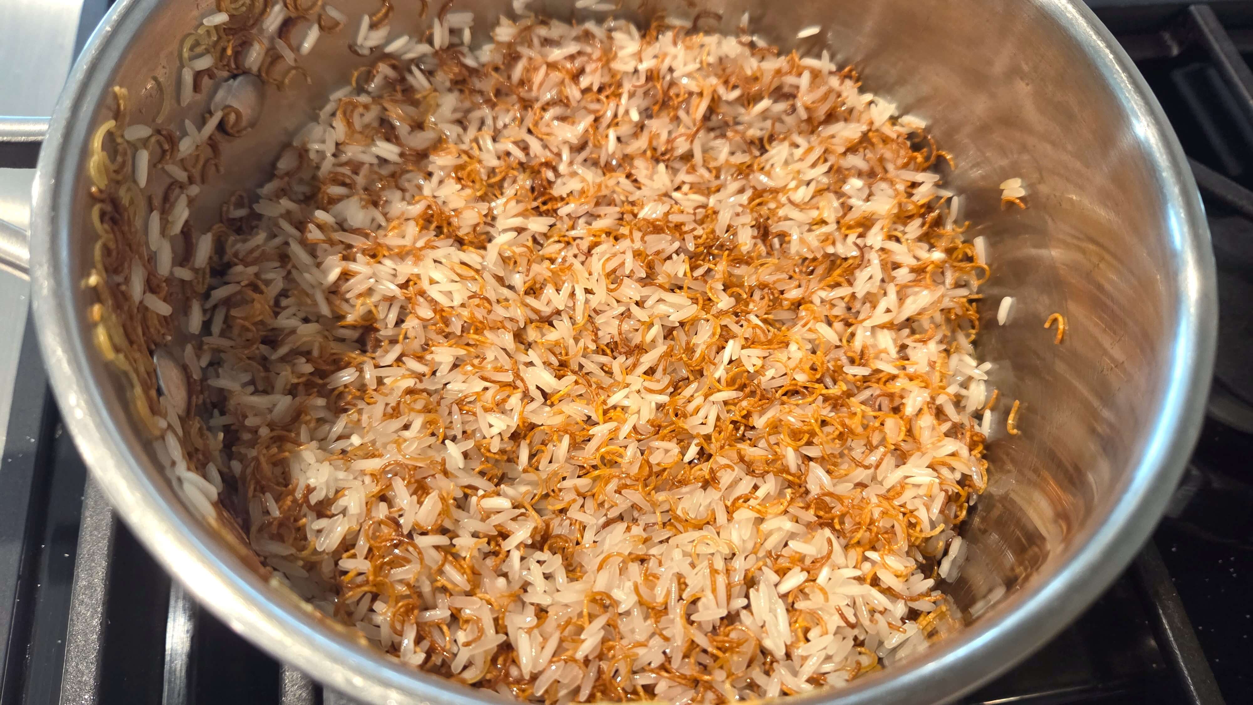 Dumped rinsed white long-grain rice into the pot with the toasted vermicelli noodles to coat the grains in oil.