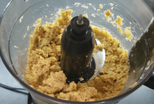 Blending chickpeas, garlic, olive oil, and lemon juice to make smooth creamy Mediterranean hummus in a food processor