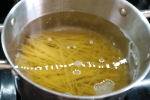 Boiling ditalini and angel hair pasta for easy homemade koshari recipe