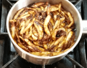 Frying onions until crispy and golden for topping koshari