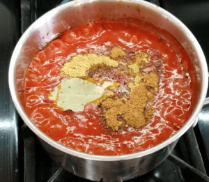 Preparing garlic tomato sauce for Egyptian koshari with spices