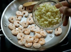Adding garlic to the shrimp for the shrimp scampi pasta