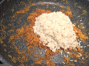 golden brown vermicelli and rinsed rice in a pan