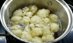 Boil cauliflower florets for a vegan crispy cauliflower recipe