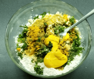 Preparing seasoned batter for vegan crispy cauliflower recipe in mixing bowl
