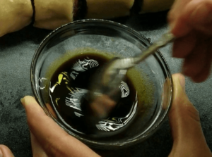 Mixing molasses with water in a small bowl