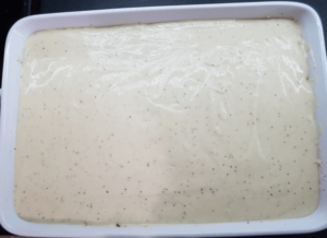 Bechamel sauce covering pasta in a baking dish.