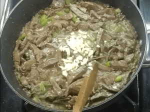 Minced garlic added to the skillet of cooked beef liver