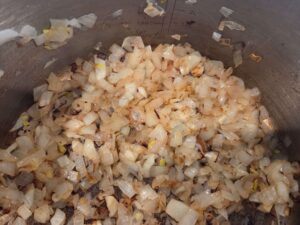 Sautéing onions in olive oil for a vegan Egyptian potato stew base