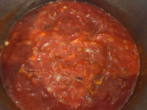 Adding tomato sauce and spices to make Egyptian potato stew vegan batates recipe