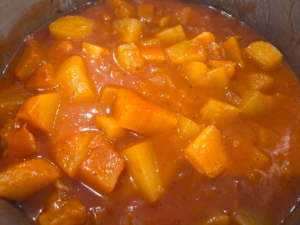 Simmering potatoes in tomato sauce until tender for Egyptian batates stew