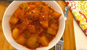 Finished vegan Egyptian potato stew garnished with fresh herbs ready to serve