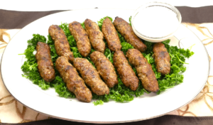 Egyptian kofta Kebabs on a bed of fresh parsley served with tahini sauce