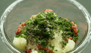 ground beef, onion pulp, parsley and spices in a bowl