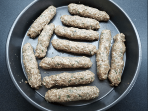 Egyptian Kofta Kebabs logs in a baking pan