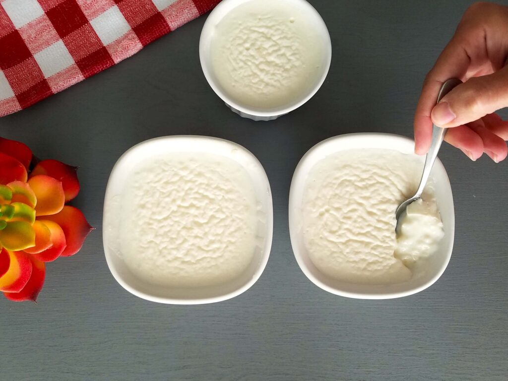 A beautiful close-up of chilled bowls of Egyptian rice pudding served plain and creamy, showcasing the glossy and velvety surface texture.