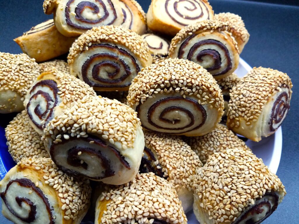 A beautiful close-up of finished vegan date pinwheel cookies arranged elegantly on a decorative serving tray.