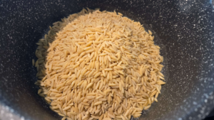 Orzo pasta added to the pot for Shorbet Lesan El Asfour