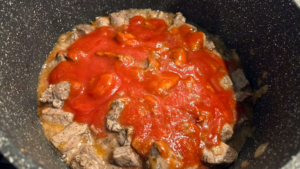 Tomato sauce added to beef for Egyptian Bazella stew