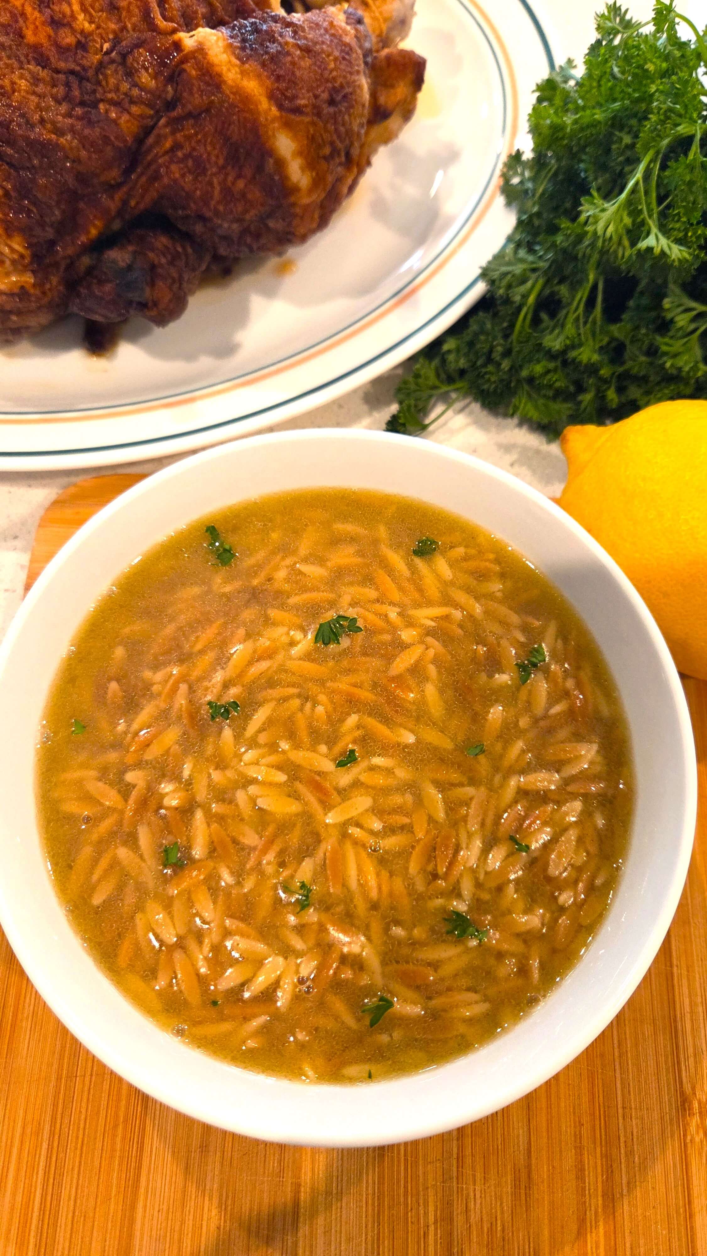 A premium close-up shot of a tender, golden-brown orzo pasta in a deep white soup bowl.