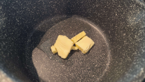 Butter and olive oil heating in a soup pot for Shorbet Lesan El Asfour recipe