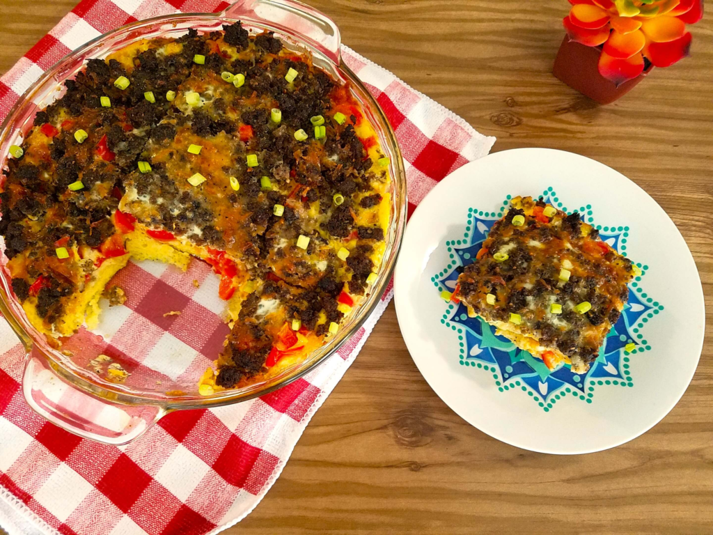 Slice of Egyptian eggah served on a plate with fresh herbs, fluffy baked egg dish for breakfast or brunch