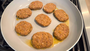 Turkish beef kofte patties browning in a skillet