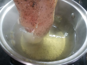 boiling chicken in broth to make Egyptian chicken noodle soup base