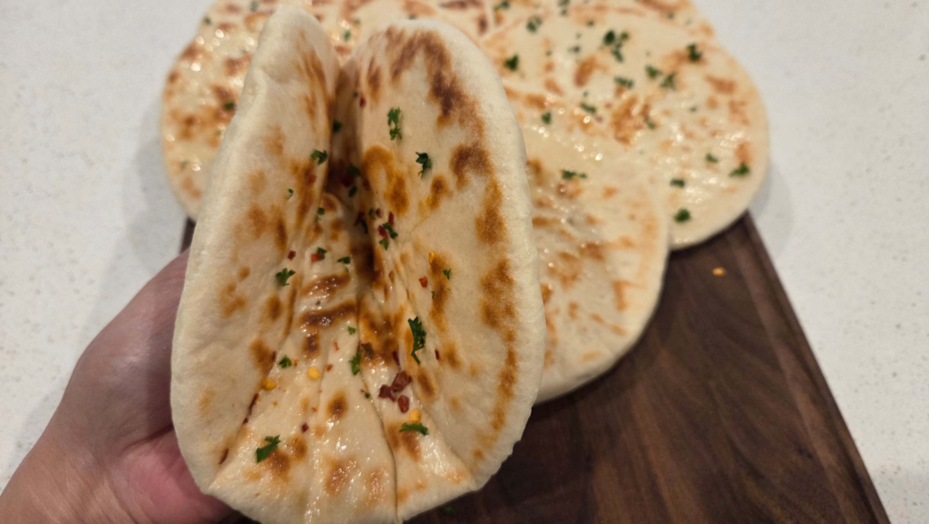Soft and fluffy Turkish flatbread bazlama, garnished with olive oil, parsley and red pepper flakes