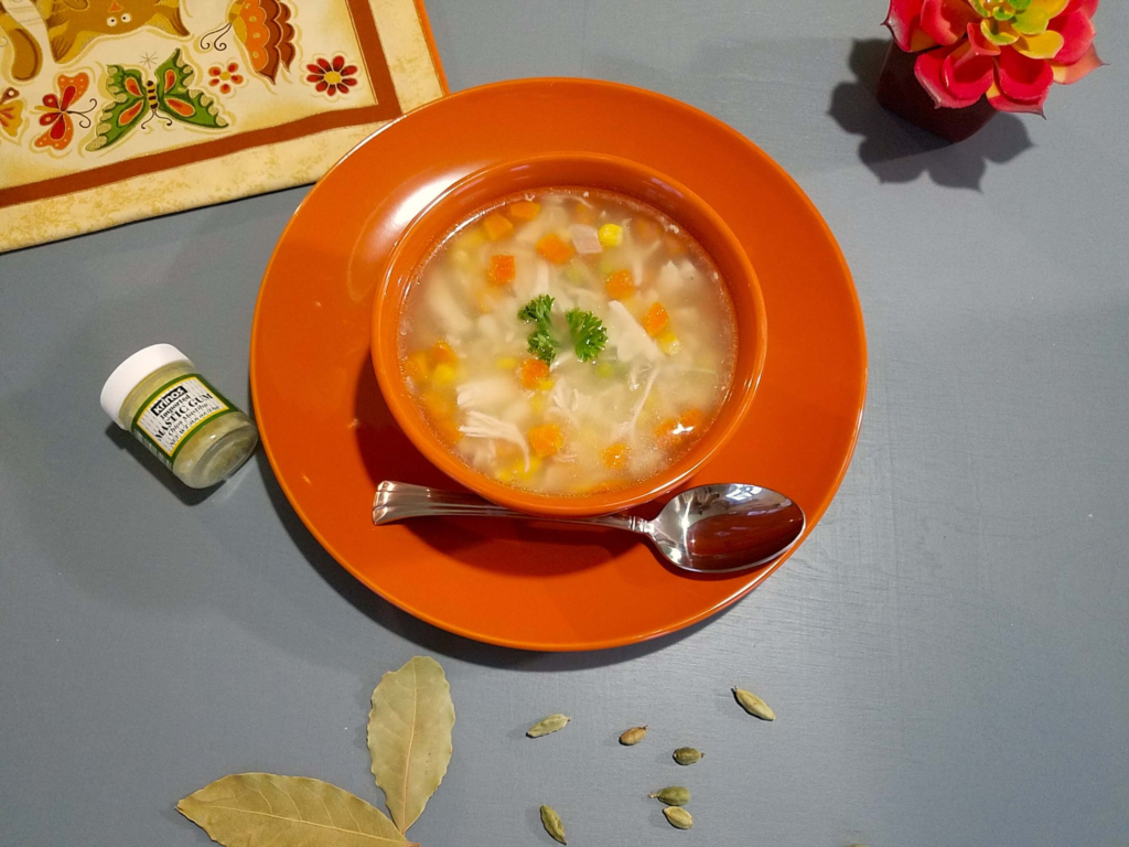 Egyptian chicken noodle soup with pasta shells, carrots, peas, and corn in a light broth.