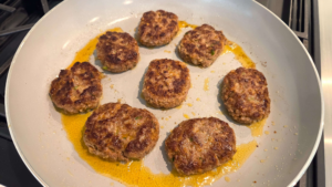 Flipping juicy Turkish beef kofte patties while cooking