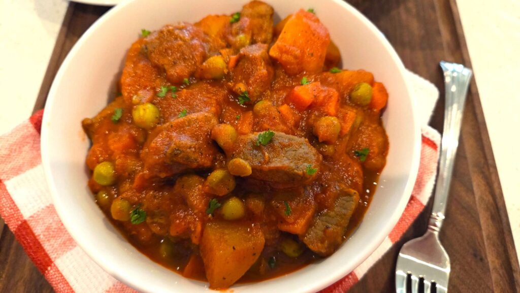 A rich Egyptian Bazella in a deep ceramic bowl, finished with a light dust of freshly chopped green parsley.