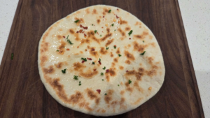 Freshly cooked Turkish flatbread brushed with olive oil parsley and red pepper flakes