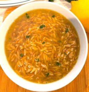 Authentic Egyptian orzo soup garnished with parsley and served with lemon