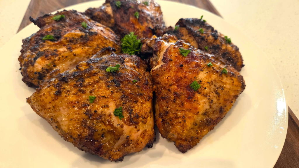 Juicy Middle Eastern grilled chicken thighs with crispy skin and fresh parsley garnish.