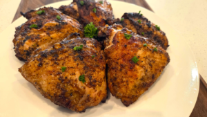 Juicy Middle Eastern grilled chicken thighs with crispy skin and fresh parsley garnish.