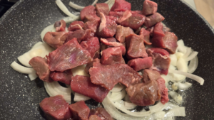 Added Beef cubes and onions in a pot while preparing kabab halla