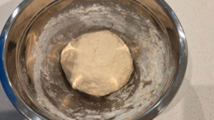 Kneading soft bazlama bread dough on a floured surface