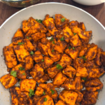 Mediterranean spicy honey garlic chicken bites served over white rice with fresh parsley and Mediterranean salad