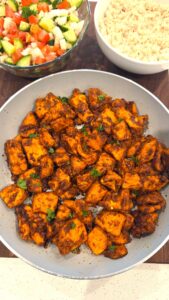 Mediterranean spicy honey garlic chicken bites served over white rice with fresh parsley and Mediterranean salad
