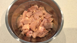 Raw chicken breast cubes in a bowl