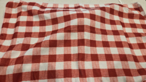 Turkish flatbread dough is covered with a kitchen towel to rest.