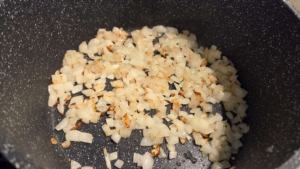 Diced onions sautéing in olive oil for Egyptian Bazella recipe