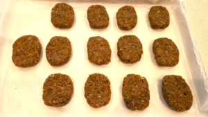Shaping Turkish beef kofte mixture into small oval patties