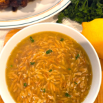 Authentic Shorbet Lesan El Asfour recipe served in a bowl with toasted orzo pasta, parsley, and lemon