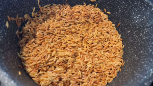 Toasting orzo pasta until golden brown for authentic Egyptian orzo soup